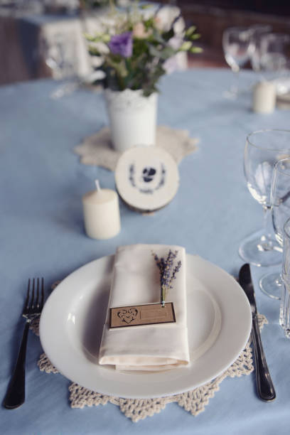 istock wedding table setting with a plate, spoon, fork and a sprig of lilac with a sign for the guest's name 1133160955