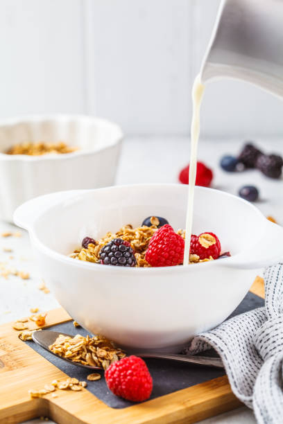 istock Breakfast food background. Granola with milk and berries on white table. 1133161761