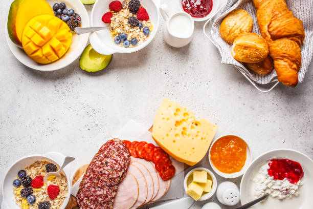istock Continental breakfast table with croissants, jam, ham, cheese,  butter, granola and fruit, copy space. 1133162224