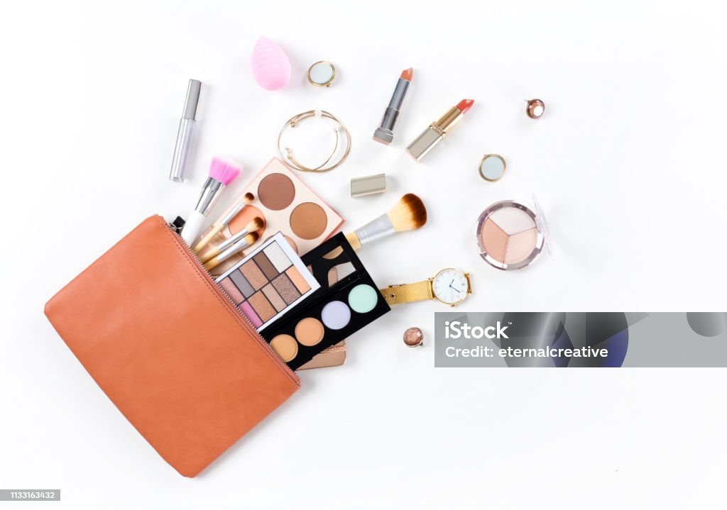 Makeup bag with cosmetic products Makeup bag with cosmetic products spilling out on to a isolated white background Make-Up Stock Photo