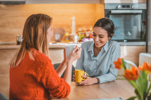 istock Female friends drinking coffee together at home 1133166830