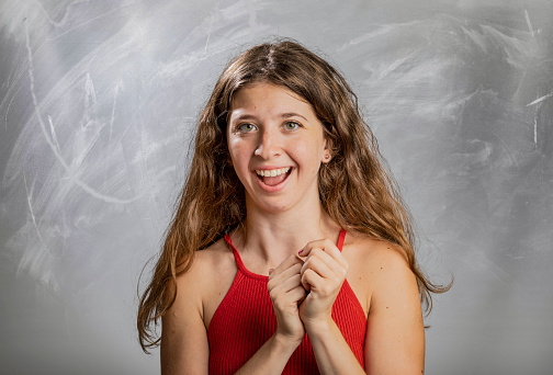 Blonde girl emotion and gesture portrait in studio smiling at camera