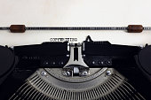 Old retro vintage black typewriter with close-up typing text Copywriting as heading on aged paper