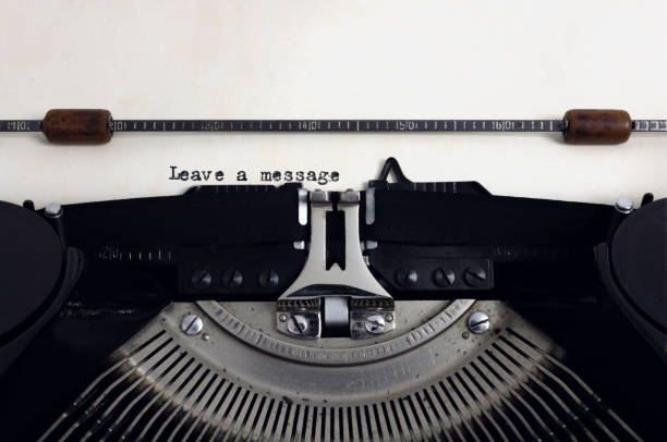 istock Old retro vintage black typewriter with close-up typing text Leave a message as heading on aged paper 1133174161