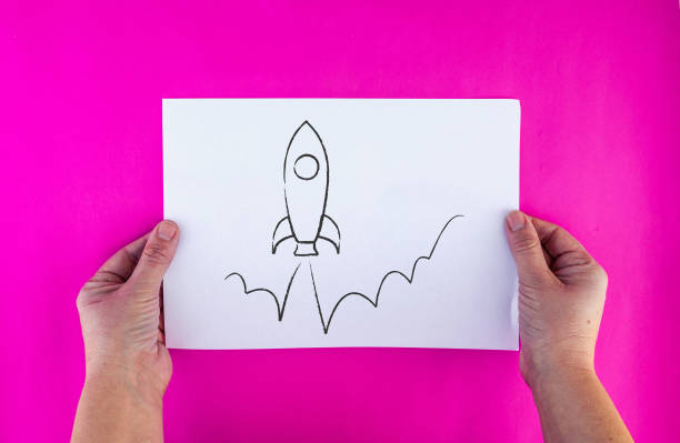 istock woman hands holds drawn rocket launch on paper sheet 1133175192