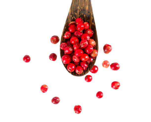 grani di pepe rosso isolati su sfondo bianco - spice condiment spoon wooden spoon foto e immagini stock