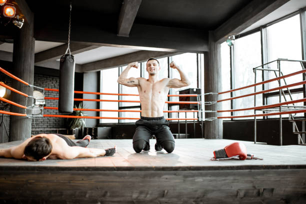 istock Boxer winner with beaten man on the boxing ring 1133176559