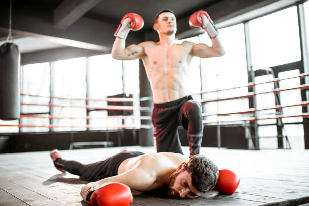 istock Boxer winner with beaten man on the boxing ring 1133176627