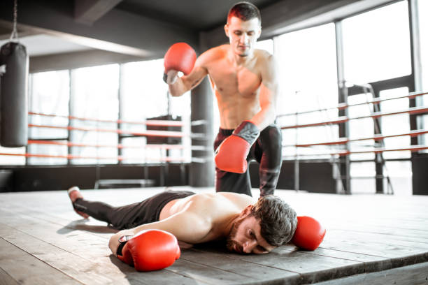 istock Boxer winner with beaten man on the boxing ring 1133176632