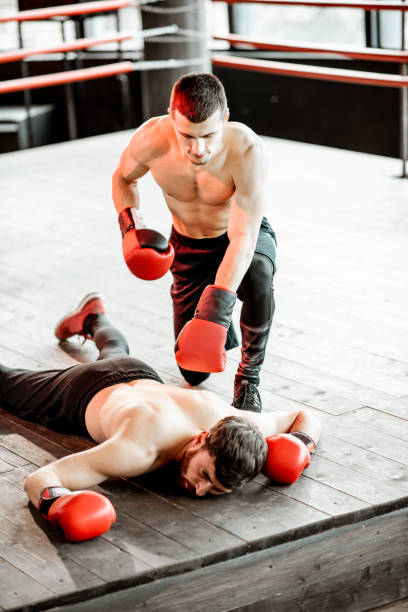 istock Boxer winner with beaten man on the boxing ring 1133176649