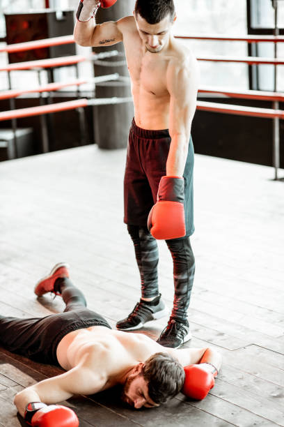 istock Boxer winner with beaten man on the boxing ring 1133176650