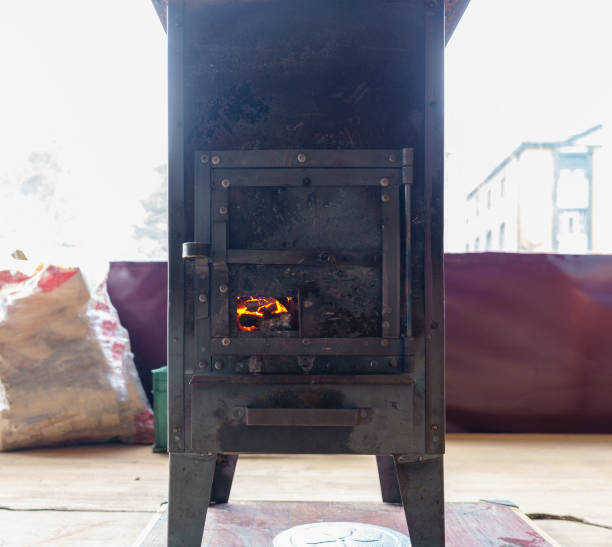 istock A black cast iron fire place with wood burning inside of it 1133178087