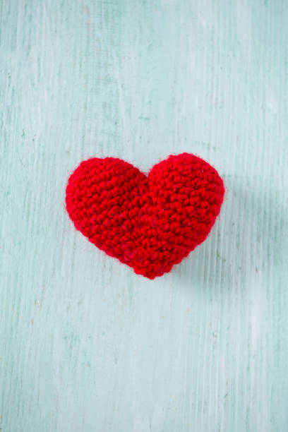 istock knitted hearts on turquoise wooden surface 1133179569