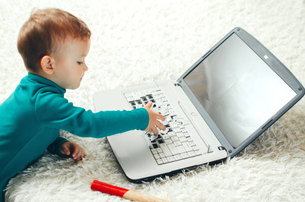 Child breaks the keys on the laptop which was left on the sofa unattended parents