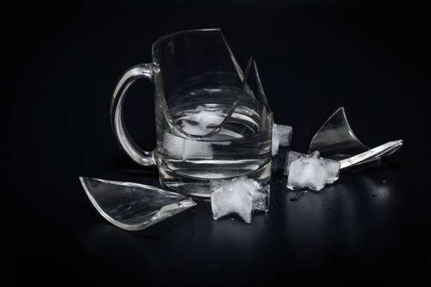 istock Broken glass cup with splinters, water and ice on a black background 1133182287