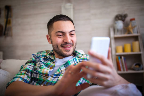 istock Happy young man at home messaging on mobile 1133182480