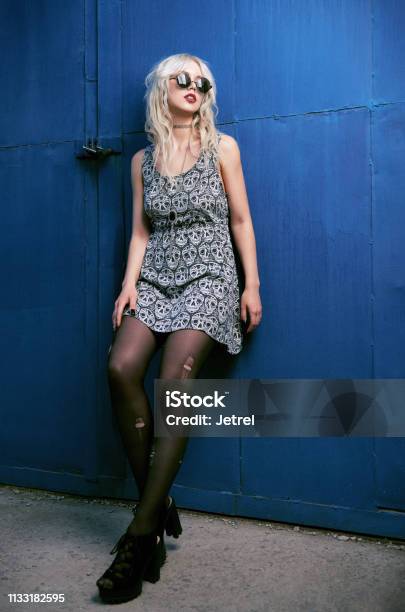 Beautiful Young Grunge Girl In Dress Ripped Pantyhose And Sunglasses Standing At Wall Full Length Outdoor Portrait Of Informal Model Stock Photo - Download Image Now