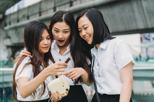 istock Three student friends looking a picture together 1133184036