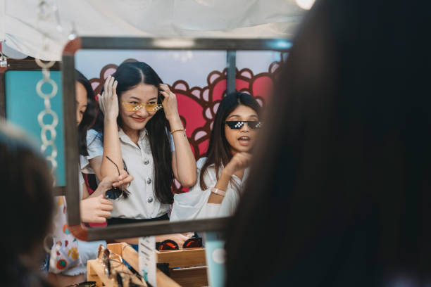 市内のナイトマーケットで買い物をしている3人の学生の友人 - siam square ストックフォトと画像