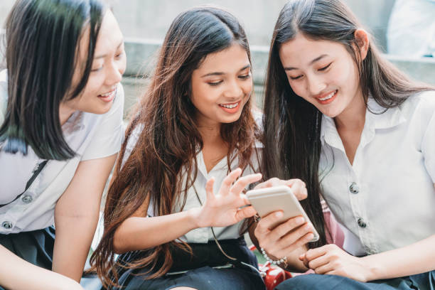 istock Three student friends using a mobile phone together in the city 1133184098