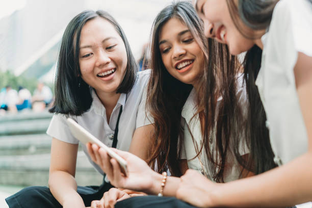 istock Three student friends using a mobile phone together in the city 1133184102