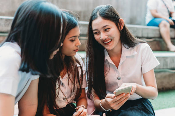 istock Three student friends using a mobile phone together in the city 1133184107