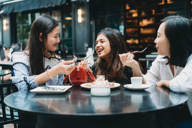 レストランで一緒にデザートを食べる3人の友人 - siam square ストックフォトと画像