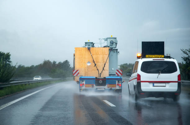 Austria, Graz, 09/14/2018: A safety escort vehicle following an oversized truck on the motorway stock photo