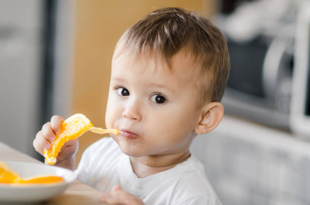 istock The child in the kitchen eating an orange 1133187575