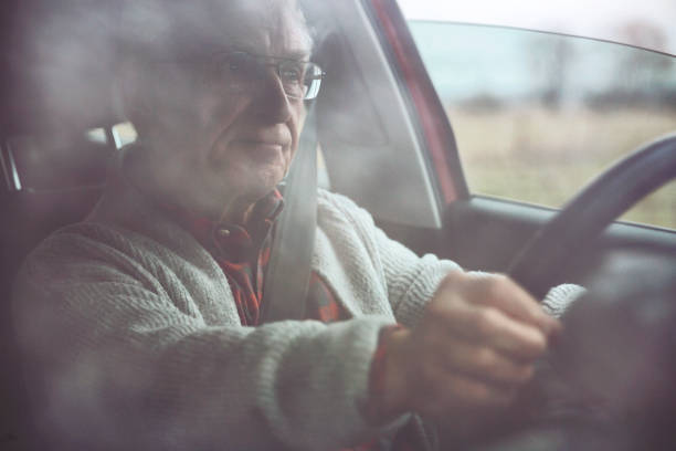 istock Old gentleman drives car 1133192502