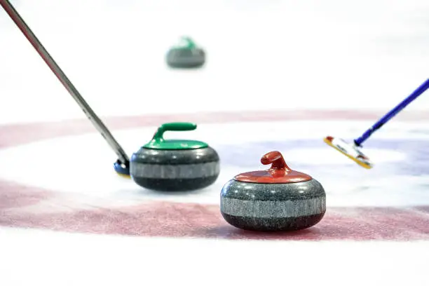 Curling stones equipment on the ice in close-up.
