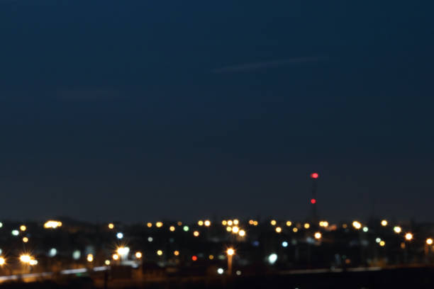 Defocused or blurred image of multi-colored lights in the city streets. Full moon. Abstract background, selective focus.