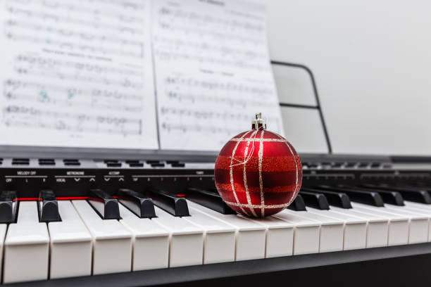 istock Christmas ball and lights on a classical piano keyboard, front view 1133197188