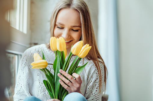 Portrait of beautiful woman with bouquet of tulips.