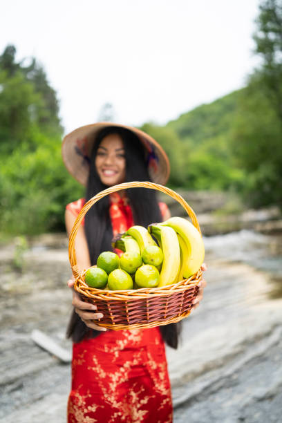 istock Young woman holding a baset with limes and bananas 1133202234