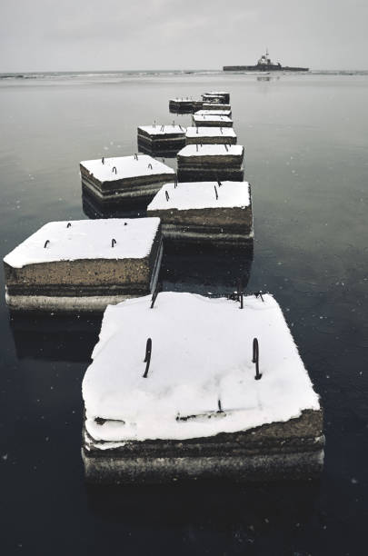 istock Building concrete blocks covered snow, shipwreck, sea, rocky coast, snowdrift 1133202779