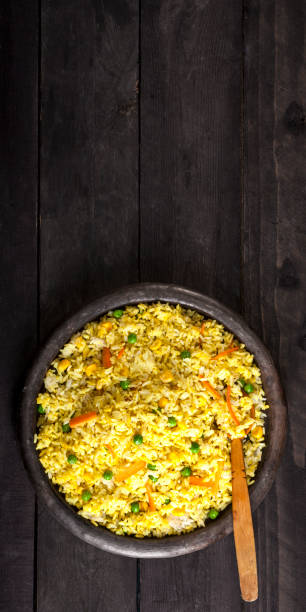 istock Cooked rice with curry and vegetables in a plate on the wood black background. 1133204168