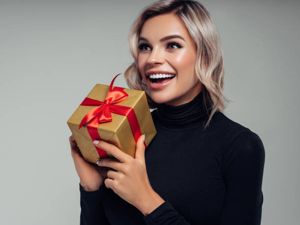 istock Happy smiling young woman holds gift box in hands 1133212730