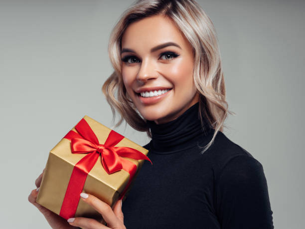 istock Happy smiling young woman holds gift box in hands 1133212770