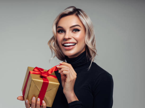 istock Happy smiling young woman holds gift box in hands 1133212814