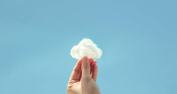 рука, держащая вату с облаком на фоне неба. развитие воображения - data exchanging green abstract стоковые фото и изображения