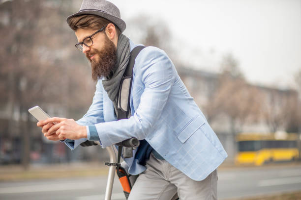 istock Young businessman with a beard smiling on kick scooter 1133221914