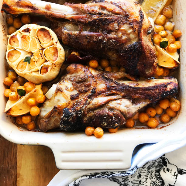 Lamb Shank Dinner in Casserole Dish Roast Lamb Shank and Garbanzo Bean Dinner in Casserole garlic bulb stock pictures, royalty-free photos & images