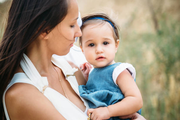 istock Happy young mother with a small daughter in hands, outdoors background 1133229451