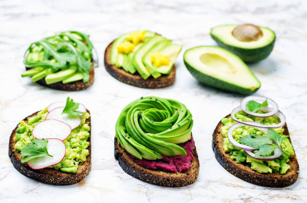 Variation of healthy rye breakfast sandwiches with avocado and toppings