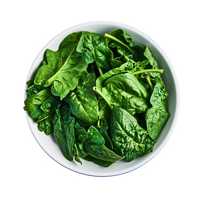 Fresh spinach leaves unwashed in bowl isolated on white background. Top view. Design element.