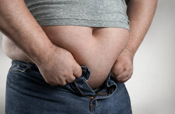homem do excesso de peso que tenta desgastar calças de brim demasiado pequenas - abdomen too small jeans overweight - fotografias e filmes do acervo