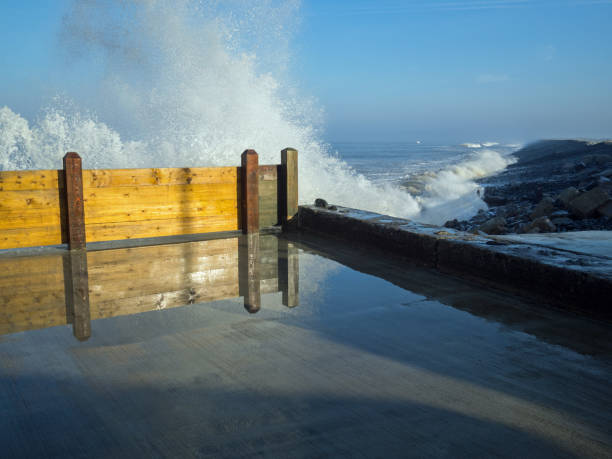 Spring tide crashing into the sea defences at Westward Ho in Devon , England