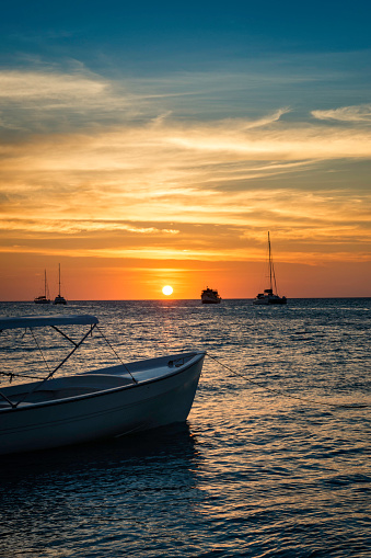 Boats anchored during a dramatic and beautiful sunset, Los Roques National Park
