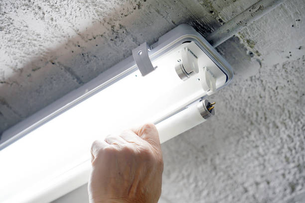 istock Electrician man worker installing fluorescent lamp 1133248430